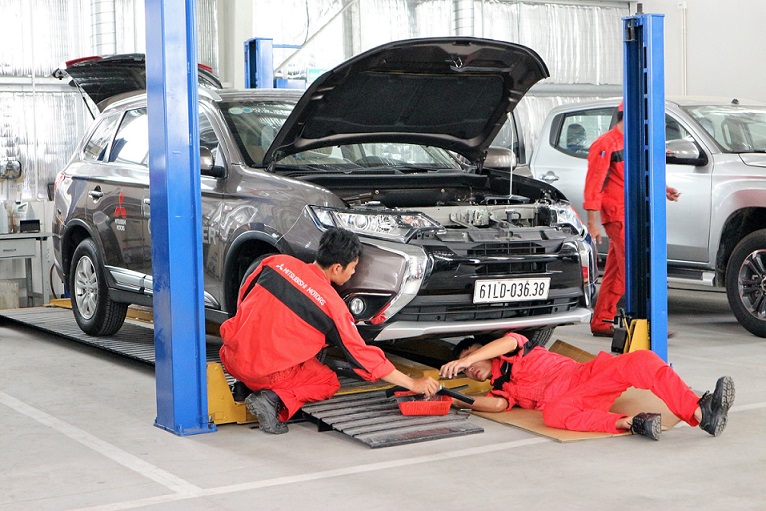 ミツビシ・モーターズ・ベトナム(MMV)の工場で車を整備している整備士