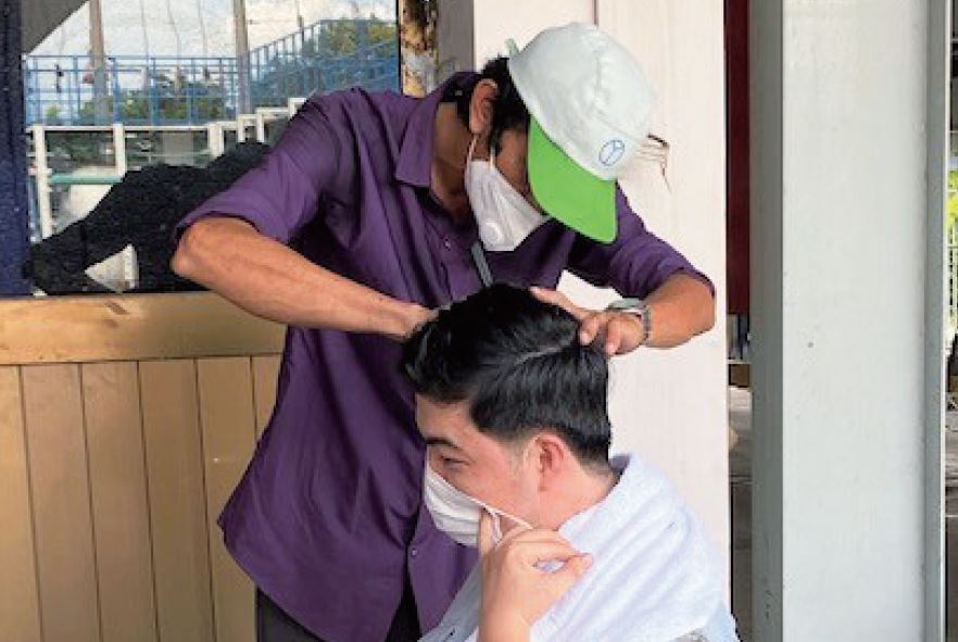 新型コロナ下の工場：理容師経験者が従業員を散髪