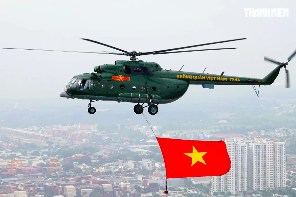 国旗を掲げホーチミン市に向かう軍用ヘリ
