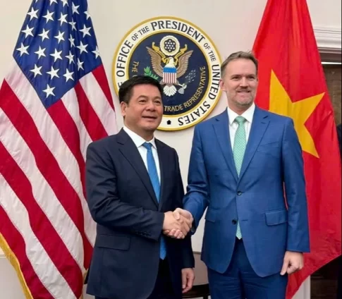 両国国旗の前で握手するベトナムのグエン・ホン・ジエン商工大臣とジェミソン・グリア米国通商代表