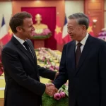 マクロン大統領と握手するトー・ラム書記長