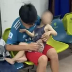 怪我をした子供を抱えて診察を待つ子供