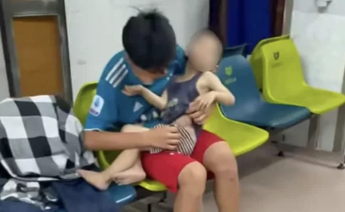 怪我をした子供を抱えて診察を待つ子供