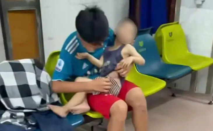 怪我をした子供を抱えて診察を待つ子供