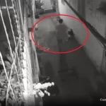 毛布に包まれた遺体のようなものを運ぶ男性
