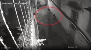 毛布に包まれた遺体のようなものを運ぶ男性