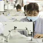 ベトナムの縫製工場でミシンを使う女性