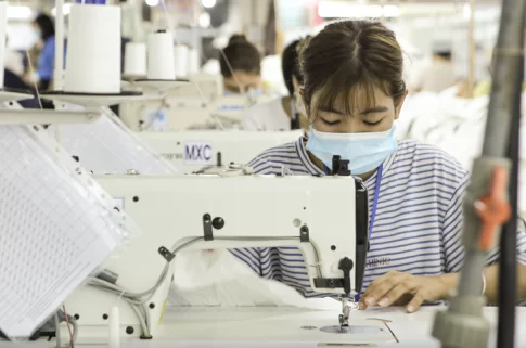 ベトナムの縫製工場でミシンを使う女性