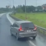 構想道路をバックする乗用車