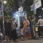 裸で倒れている若者が発見された路地で心配する住民たち