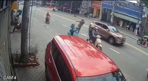 走行中のバイクを蹴る男性