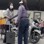 バス待ちしている若い女性の荷物を蹴る露天商の女性