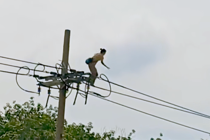 電線を渡ろうとする女性