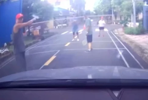 道路上にネットを張ってバドミントンする男たち