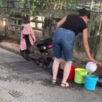 屋台の食器をすすぐ女性