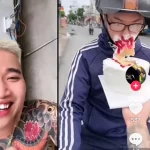 信号待ちのバイクドライバーの顔にケーキを押し付ける