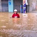 冠水したダナン市内の道路を歩く女性