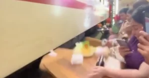 ハノイの線路カフェで列車がテーブルを吹き飛ばす瞬間