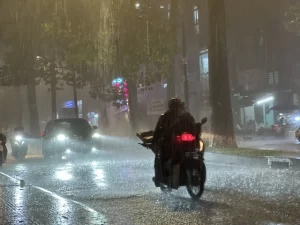 大雨のホーチミン市内を走るバイク