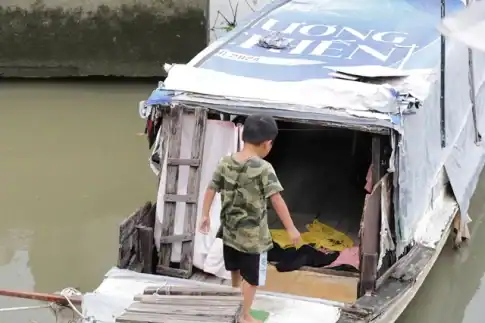 ホーチミン市の運河沿いにある住居兼用の古い船