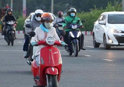 ホーチミン市の早朝の気温低下により厚着をしてバイクに乗る市民