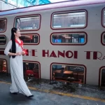 ５か所の城門を巡るハノイ観光列車の前を歩くアオザイ美女