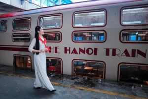 ５か所の城門を巡るハノイ観光列車の前を歩くアオザイ美女