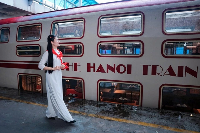 ５か所の城門を巡るハノイ観光列車の前を歩くアオザイ美女