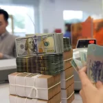 銀行カウンターに積まれたUSDとVNDの札束