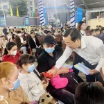 テト（旧正月）に故郷へ帰るバスに乗る労働者の子供たちにお年玉を贈るホーチミン市党委員会常任副書記のレ・クオック・フォン氏
