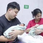 病院で生まれたばかりの赤ちゃんを抱く夫婦