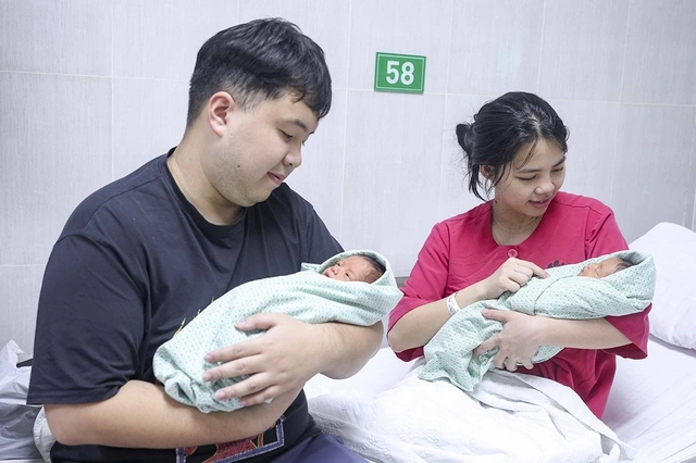 病院で生まれたばかりの赤ちゃんを抱く夫婦
