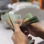 ベトナムの最高紙幣50万VND札を数える人
