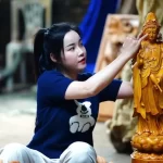 ダナンの女性木彫刻家レ・ティ・ハーさんと自作の観音像