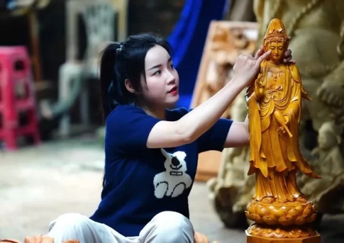 ダナンの女性木彫刻家レ・ティ・ハーさんと自作の観音像