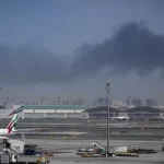 中東地域での紛争ぼっ発により黒煙が上がるドバイの空港