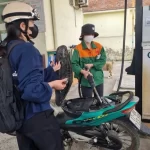 ベトナムのガソリンスタンドでバイクに給油する人