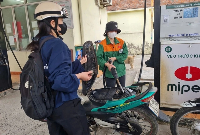ベトナムのガソリンスタンドでバイクに給油する人