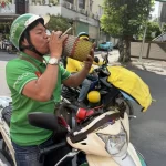 猛暑の中、こまめに水分補給するホーチミン市の配車ドライバー