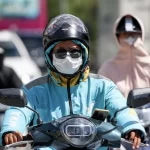 猛暑の中バイクを運転するベトナムのドライバー