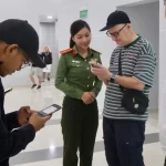 フーコック国際空港で電子事前申告システム（PAI）の説明を受ける外国人旅行者