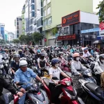 通勤時間帯に道路を埋め尽くすホーチミン市内のバイク群