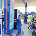 E10ガソリン販売開始に伴い設定を確認するベトナムのガソリンスタンド店員
