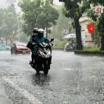 大雨のホーチミン市内を走るバイク