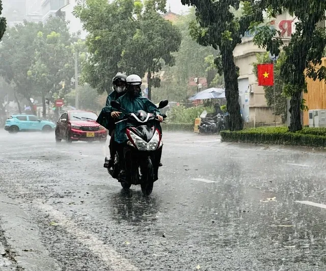 大雨のホーチミン市内を走るバイク