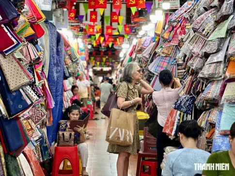 ベトナムの伝統的な市場で買い物する外国人