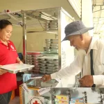 ホーチミン市の思いやり食堂で食事を購入する男性