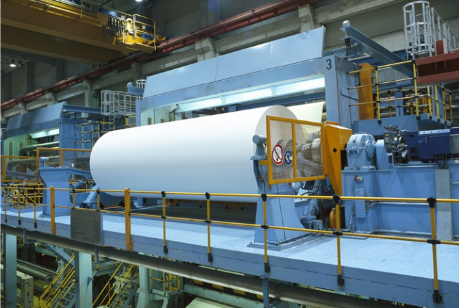 製紙工場で稼働する巨大な抄紙機（しょうしき）のリールパート