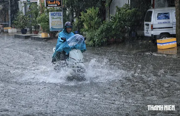 ホーチミン市内の冠水した道路を走るバイク