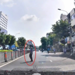 横断歩道のない場所で道路を渡ろうとするホーチミン市内の歩行者